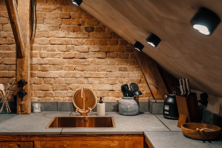 Cabin No.3: Kitchen with copper sink in front of brick wall, Hof Bissee