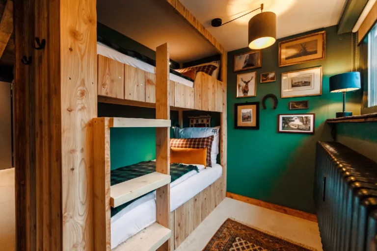 Cabin No.3: Wooden bunk beds in front of a green picture wall, Hof Bissee