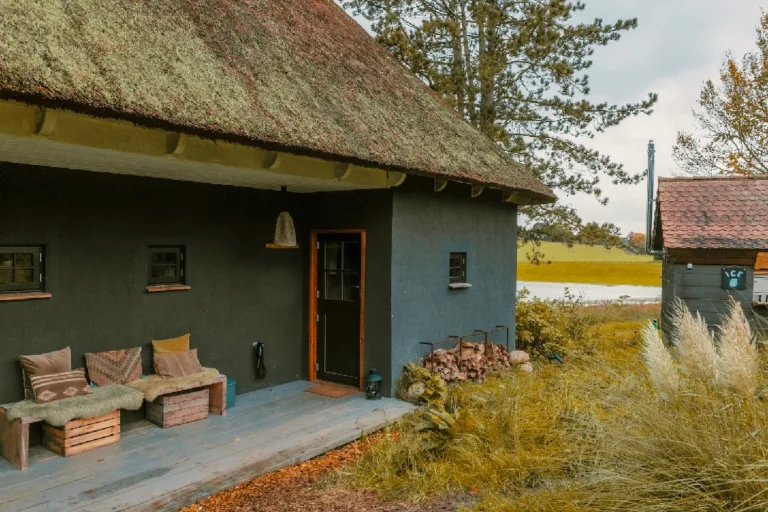 Cabin River: Exterior view with thatched roof and bench, Hof Bissee