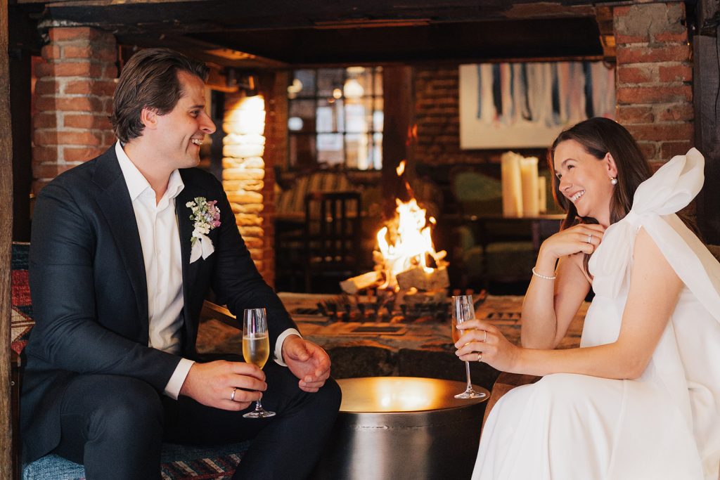 Wedding venue: Bride and groom with sparkling wine by the fireplace, Hof Bissee