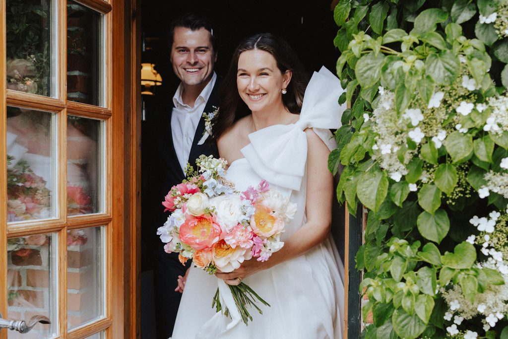 Wedding venue: Bride and groom with a bouquet at the door, Hof Bissee