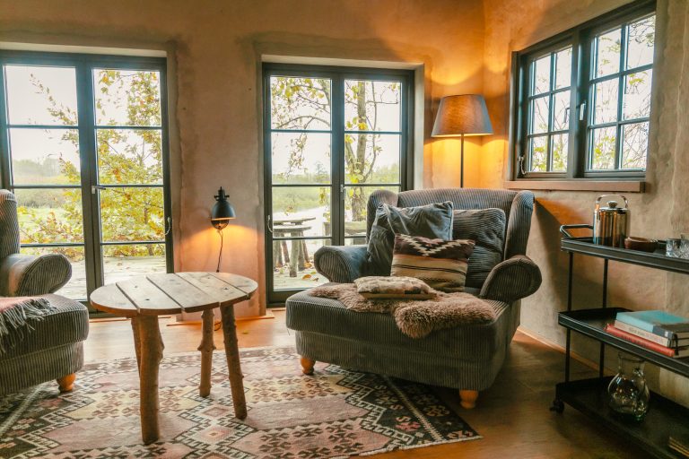Cabin River: Seating area with wing chair and wooden table by the windows, Hof Bissee