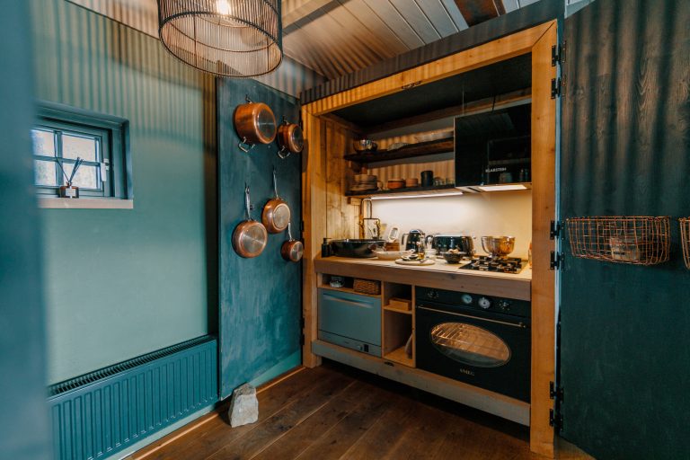 Cabin Forrest: Compact fitted kitchen with copper pots, Hof Bissee