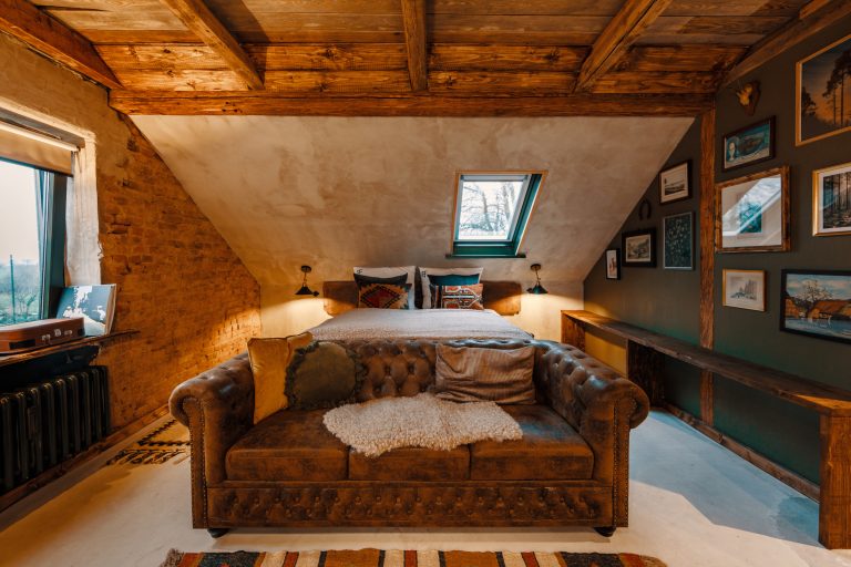 Cabin No.4: Chesterfield sofa in front of the double bed under wooden beams, Hof Bissee