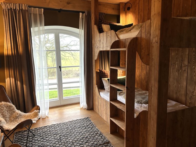 Room No.2: Wooden bunk bed and armchair by the arched window, Hof Bissee