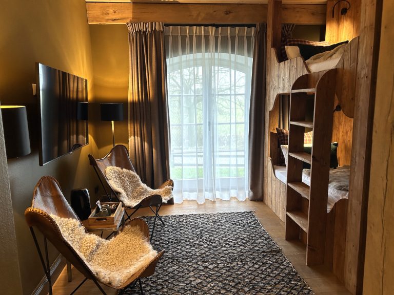 Room No.2: Seating area with sheepskin armchairs and TV, Hof Bissee