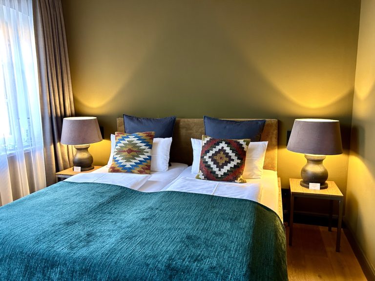 Room No.5: Double bed with petrol-blue bedspread, Hof Bissee