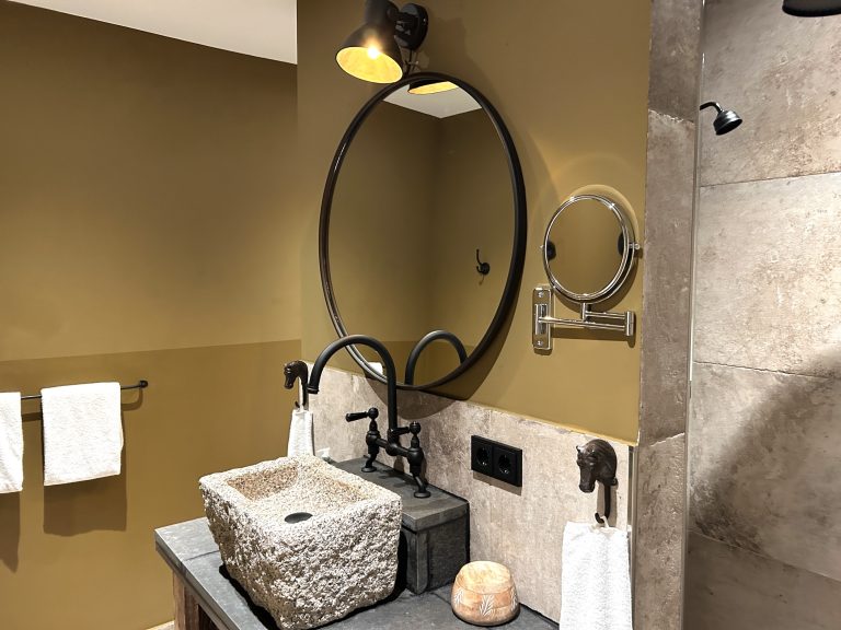 Room No.5: Bathroom with stone washbasin and round mirror, Hof Bissee