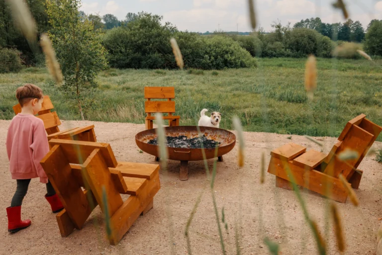 BBQ area River: Child at the fire bowl between wooden loungers, Hof Bissee