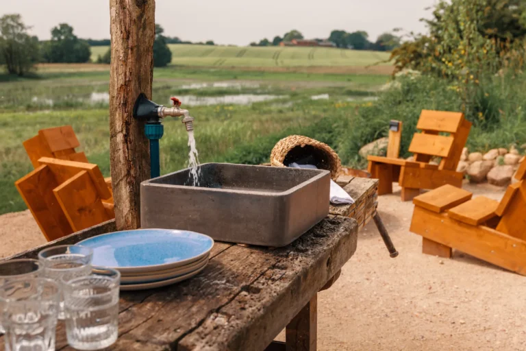 BBQ area River: Wooden table with stone sink, tap and crockery, Hof Bissee