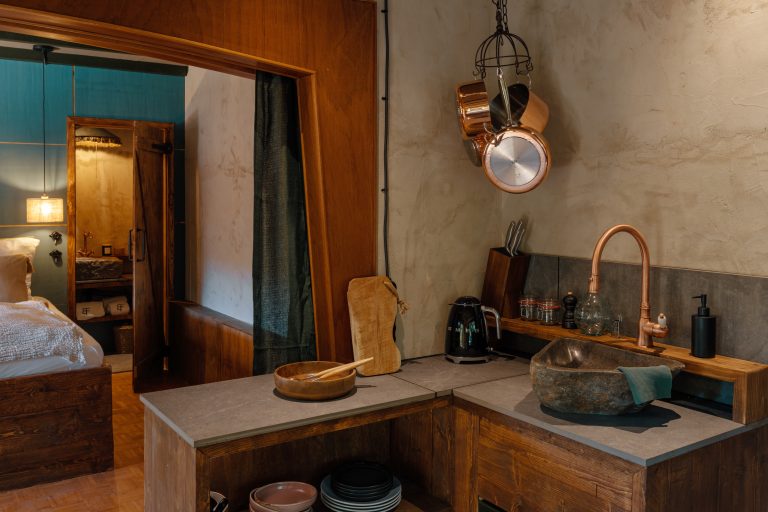Cabin No.5: Kitchenette with copper pots and view of the bedroom, Hof Bissee