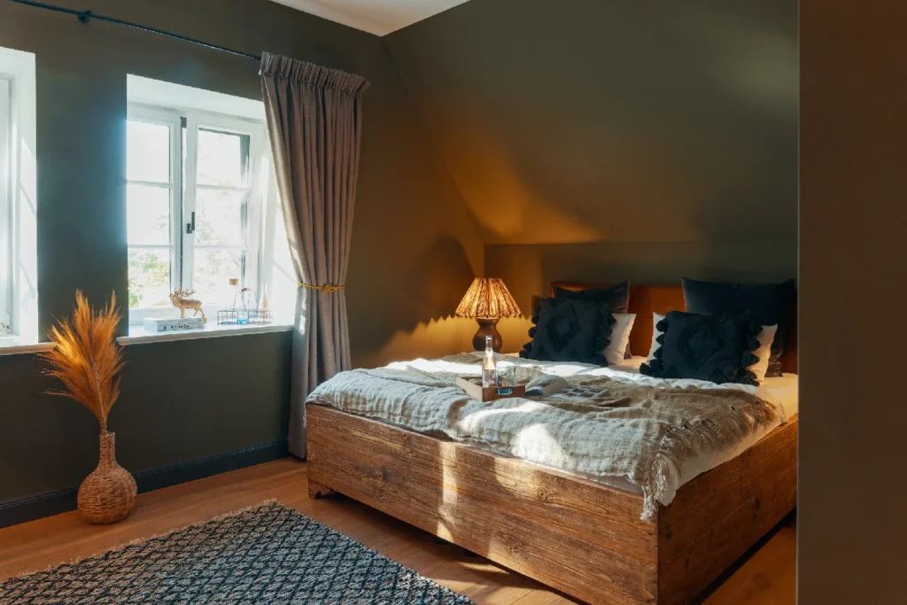Room No.7: Doppelbett mit Holzrahmen und Trockenblumen, Hof Bissee