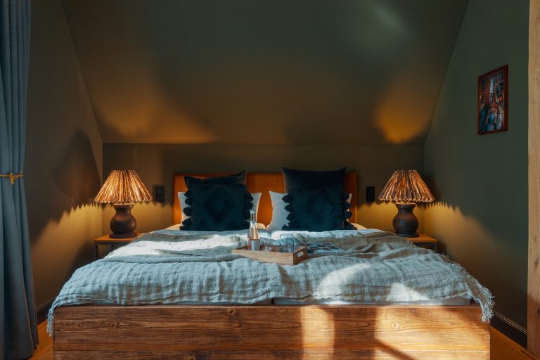 Room No.7: Double bed with blue pillows and bedside lamps, Hof Bissee