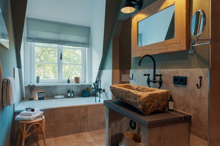 Room No.7: Bathroom with stone washbasin, mirror and bathtub, Hof Bissee