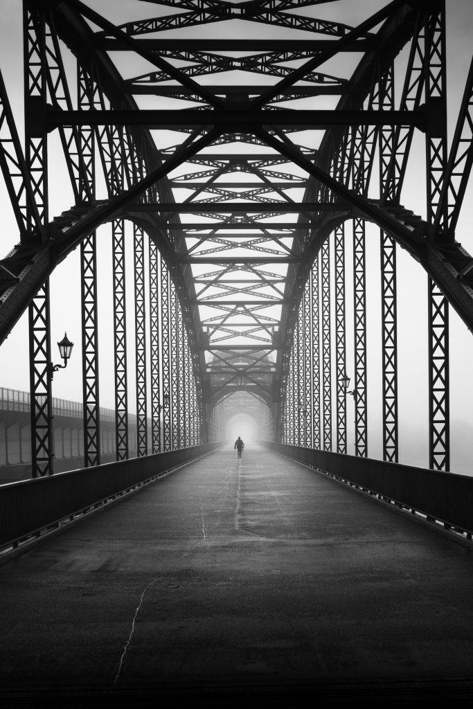 Art exhibition SVENSØN: Person on a steel bridge in the fog, Hof Bissee